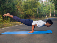 Man performing advanced bodyweight yoga pose outdoors on a mat